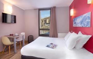 伊索拉2000SOWELL RESIDENCES New Chastillon的酒店客房设有一张带桌子和窗户的床。
