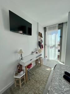 科拉雷侯Casa Uma的一间卧室配有一张桌子和一台墙上的电视。