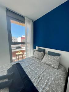 科拉雷侯Casa Uma的蓝色的卧室设有床和大窗户