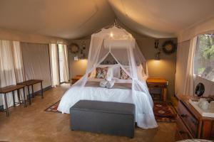 斯库库扎Umkumbe Bush Lodge - Luxury Tented Camp的一间卧室配有一张带天蓬的床