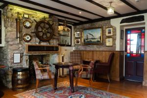 锡豪西斯The Olde Ship Inn的一间设有桌子和石墙的用餐室
