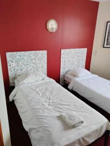 Le Bois de Cisecontact hôtel Le Temps Perdu的红色墙壁的客房内的两张床