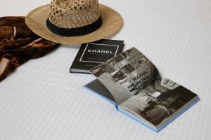 里雄莱锡安Rephael House Boutique Hotel的一本书和一本杂志旁边的草帽
