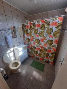 伊达贾伊Suíte Azul com SmartTv, Cama Queen e Banheiro Privativo的浴室设有卫生间和花卉淋浴帘