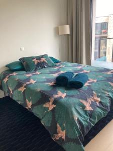 根特Cozy two bedroom Apartment near city centre Gent的一张带五颜六色的被子和叶子的床