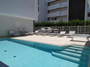 利多迪耶索罗Jesolo Appartamenti F2 - Coral Red的一座带躺椅的游泳池和一座建筑