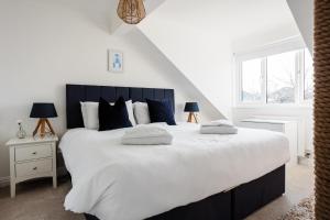托特兰Sunseekers - Colwell Bay的卧室配有带蓝色枕头的大型白色床