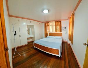 阿拉米诺斯150 Lucap Road的一间卧室配有一张床,铺有木地板