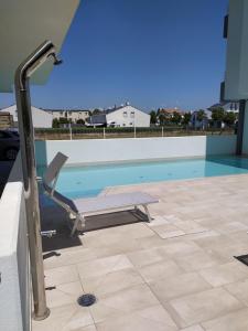 利多迪耶索罗Jesolo Appartamenti F2 - Ocean Blue的游泳池旁带躺椅的游泳池