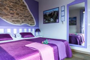 费尔特雷Casa Novecento的紫色卧室配有一张床和镜子