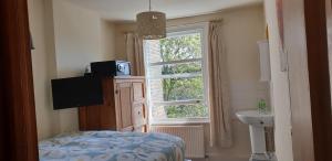 伦敦巴米巴杰背包客旅舍的卧室设有窗户、床和水槽