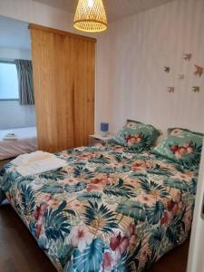孔波尔塔Sado House 3的一间卧室配有一张带花卉棉被的床
