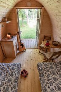 岑讷Campingpod back to basic的一间铺有木地板的客房和一间带吉他的房间