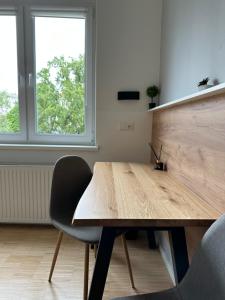 维也纳Lion`s Rooms n Apartments的窗户客房内的一张木桌和两把椅子