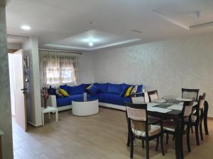 萨伊迪耶Appart calme, neuf à 5mn de la plage SAADIA的客厅配有蓝色的沙发和桌子