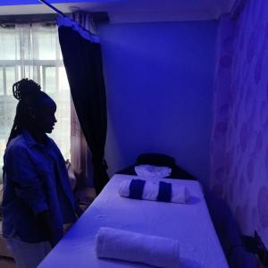 纳库鲁Kentania Hotel & Spa, Nakuru - Kenya的站在蓝色房间,有床的女人