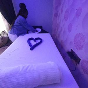 纳库鲁Kentania Hotel & Spa, Nakuru - Kenya的坐在床上的女人,心里想着