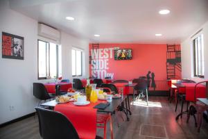 马德里Casual del Teatro Madrid的一间拥有红色墙壁和桌椅的用餐室