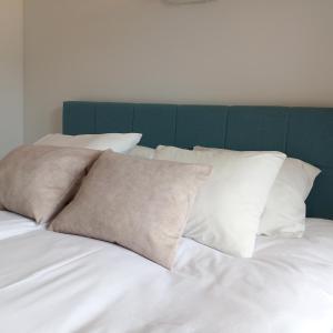 亚斯塔尔尼亚Na Fali的一张带白色枕头和绿色床头板的床