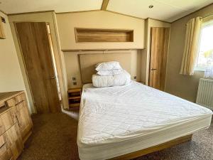 大雅茅斯Beautiful Caravan With Sea Views At California Cliffs In Scratby Ref 50010oc的一间卧室配有带白色床单和枕头的床。