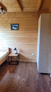 波拉齐克Na Równej Bieszczady的一间设有木墙的房间,里面设有桌子