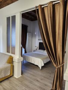 博尔戈马内罗Mansarde & Suite Maison 1706 Lago Orta的一间卧室配有两张床和窗帘