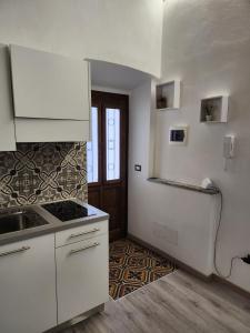 博尔戈马内罗Mansarde & Suite Maison 1706 Lago Orta的厨房配有白色橱柜和台面