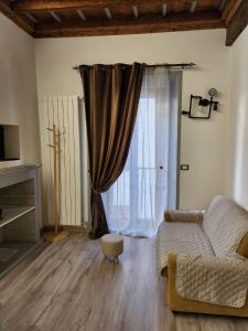 博尔戈马内罗Mansarde & Suite Maison 1706 Lago Orta的带沙发和窗户的客厅