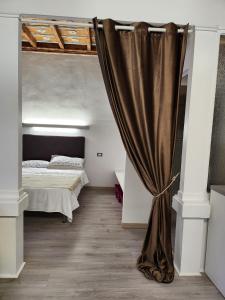 博尔戈马内罗Mansarde & Suite Maison 1706 Lago Orta的一间卧室配有床和窗帘