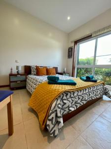 Vila ChãMindelo Beach House的一间卧室设有一张床和一个大窗户