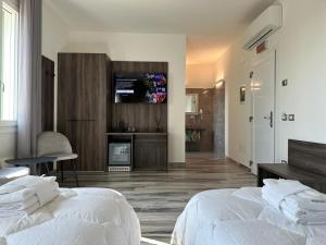 帕多瓦Royal Garden luxury rooms的一间卧室设有两张床,墙上配有电视。