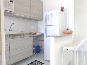 伯迪亚哥Apartamento a 100 metros da Praia的白色的厨房配有白色冰箱和凳子