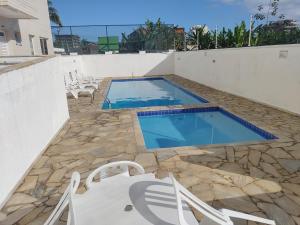 伯迪亚哥Apartamento a 100 metros da Praia的一个带椅子和桌子的游泳池