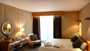 多维尔多维尔高尔夫阿米拉特酒店的酒店客房,配有床和镜子