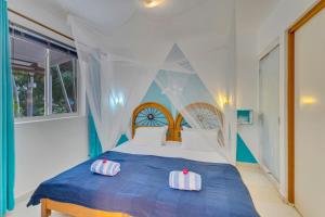 克拉伦代克Tropical Divers Resort的卧室配有蓝色和白色的床和2个枕头