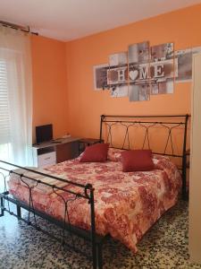 索里根安诺沃Andrea affittacamere e B&B的一间卧室配有一张带橙色墙壁的床和一张书桌