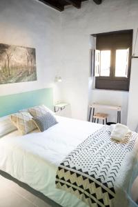 加尔达尔Casa El Terrero的卧室设有一张白色大床和一扇窗户。