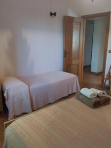 IelsiAgriturismo Masseria Testa Ciruglio的卧室配有两张床和毛巾,位于地板上