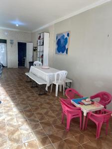 特赖里Casinha Valdenia: No paraíso com Wi-Fi, em Mundaú的用餐室配有粉红色的椅子、桌子和桌椅