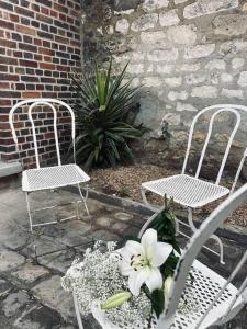 贡比涅Le Maurice 6 - Duplex的庭院里摆放着两把椅子和一株鲜花