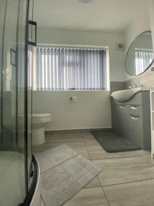 霍利Gatwick Deluxe En-suite Rooms的带淋浴、盥洗盆和卫生间的浴室