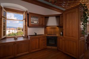 伊兹拉Antoinette Mansion的厨房配有木制橱柜和窗户。