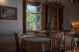 伊兹拉Antoinette Mansion的一间带桌椅和窗户的用餐室