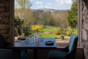 艾斯加斯Aysgarth Falls Hotel & Restaurant的一张桌子,从窗户可欣赏到花园美景