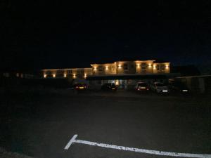 桑当Friends Hotel的一座有汽车在晚上停在停车场的建筑