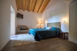帕尔马诺瓦Casale San Pietro的一间卧室,卧室内配有一张床和一把椅子