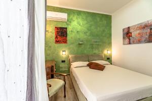 萨沃纳Sogno d'Estate - Appartmento的一间卧室设有两张床和绿色的墙壁