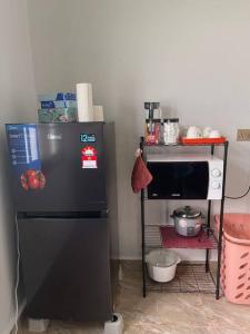 Kampung KerangiVilla President Homestay -4 bedroom Aircond WIFI Vacations Home的厨房配有黑色冰箱和微波炉。
