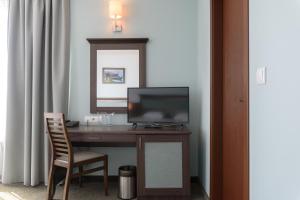阳光海滩狮阳海滩酒店的一张桌子,电视机和椅子放在房间里