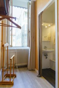 里昂剧场酒店的一间带水槽、窗户和椅子的浴室